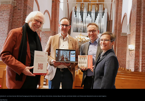 Vier Personen in einer Kirche mit Orgel im Hintergrund.