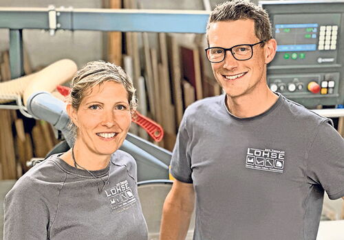 Mann und Frau in Werkstatt vor Holzbearbeitungsmaschine