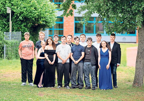 Gruppe von Jugendlichen steht in formeller Kleidung im Freien.