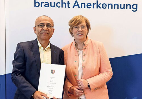 Zwei Personen bei Auszeichnungszeremonie.