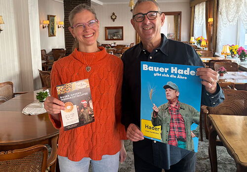 Zwei Personen halten Werbematerial in einem Café.