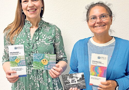 Zwei Frauen halten Prospekte und Karten.