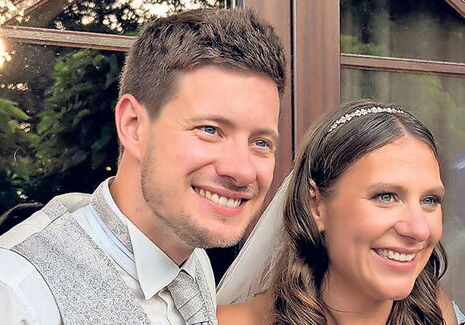 Brautpaar lächelt bei einer Hochzeit im Freien