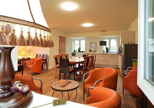 Gemütlicher Wohnraum mit Esstisch und Ledersesseln.