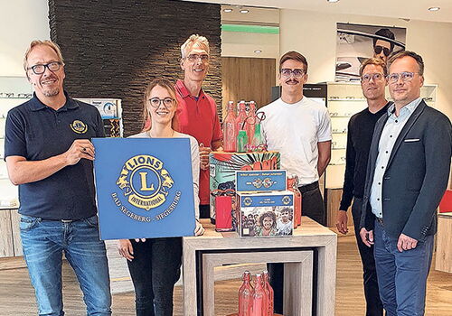 Sechs Personen posieren mit Lions-Club-Logo und Geschenken.