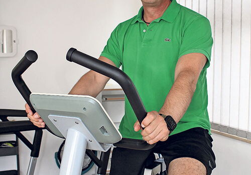 Mann auf Heimtrainer im Fitnessraum.