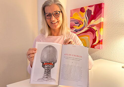 Frau zeigt offenes Buch über Atlas-Energie in Praxis.