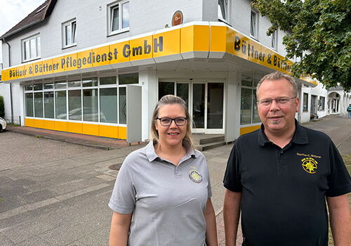 Zwei Personen vor dem Büro des Pflegedienstes Büttner & Büttner.