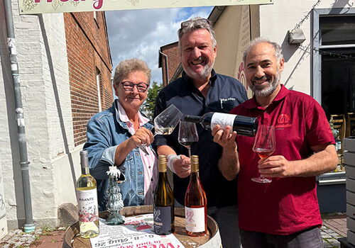 Drei Personen präsentieren Wein beim Weinfest in Bad Segeberg.