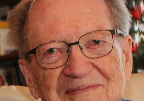 Älterer Mann mit Brille lächelt freundlich in die Kamera.