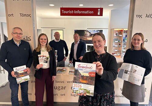 Gruppe vor einer Tourist-Information mit Broschüren.