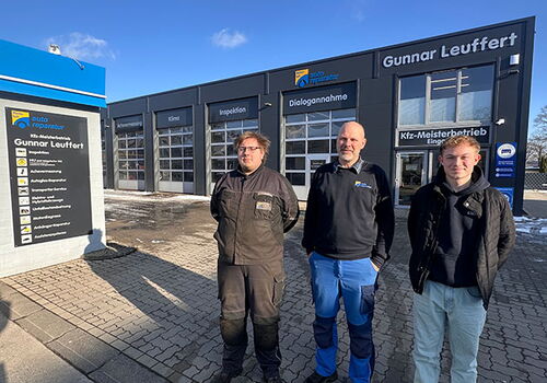 Drei Männer stehen vor einer Autowerkstatt Gunnar Leuffert.