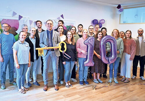 Gruppe feiert Jubiläum mit Luftballons in Raum