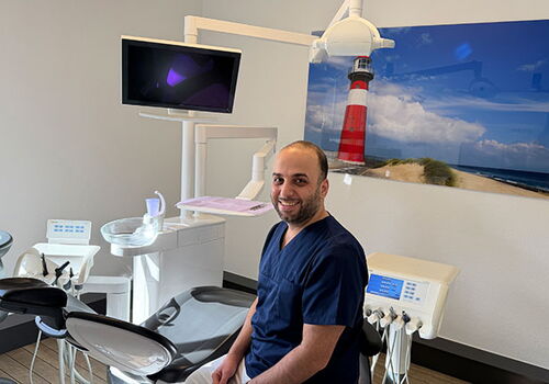 Zahnarzt im Behandlungsraum mit Leuchtturmbild