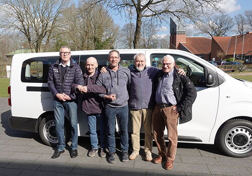 Fünf Männer stehen vor einem weißen Van.