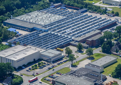 Luftaufnahme einer großen Industriefabrik mit mehreren Gebäuden.
