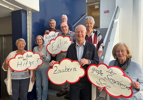 Ältere Personen halten Sprechblasen mit Text.