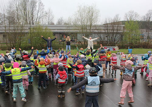 Kinder machen Gymnastik im Freien mit Instruktoren.