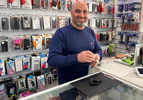 Mann mit Kabel in einem Handygeschäft.