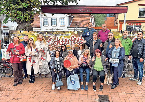 Gruppe posiert beim Herbstfest vor einem Banner.
