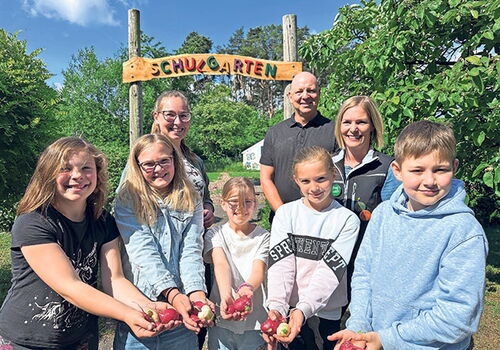 Kinder im Schulgartenprojekt in Leezen mit geernteten Radieschen
