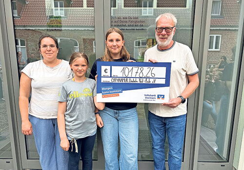 Vier Personen halten einen großen Spendenscheck.