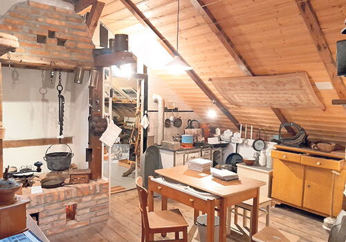 Gemütliches Dachboden-Zimmer mit Küchenutensilien und Kamin.
