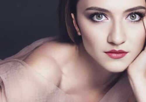 Porträt einer Frau mit hellem Make-up und elegantem Blick.