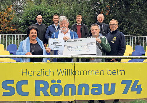Gruppe mit Scheck vor SC Rönnau 74 Schild.