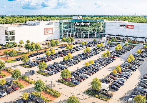 Großes Möbelhaus mit Parkplatz voller Autos