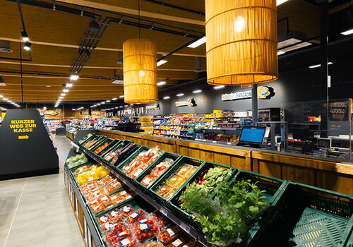 Ein Supermarktgang mit frischem Obst und Gemüse.
