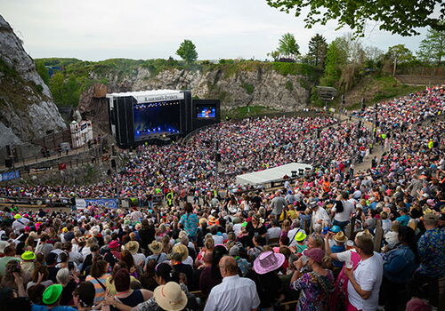 Großes Publikum bei einem Open-Air-Konzert in einer Felsarena.