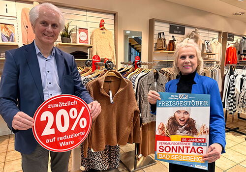 Zwei Personen präsentieren Rabatt im Bekleidungsgeschäft.