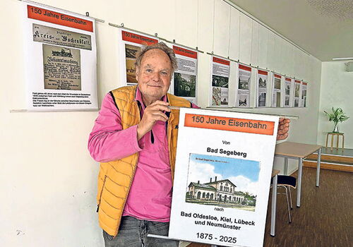 Mann hält Banner zu 150 Jahre Eisenbahn in Bad Segeberg.