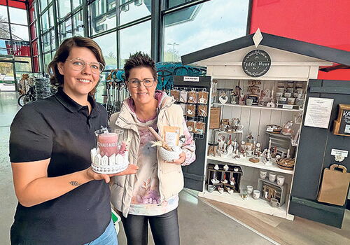 Zwei Frauen vor einem Geschenkestand mit Dekorationen.
