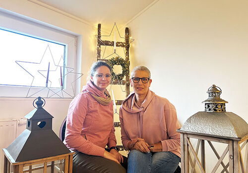 Zwei Frauen sitzen in einem dekorativen Raum mit Laternen.