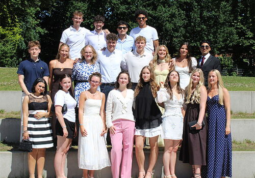 Gruppe junger Menschen in eleganter Kleidung im Freien.