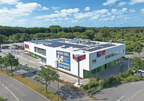 Gebäude mit Küchentrends-Werbung und Solarpanels.