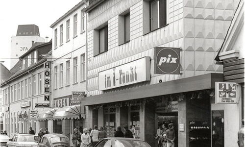 Straßenansicht Kurhausstrasse 6 mit Geschäften und Autos.