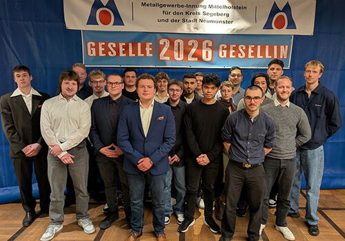 Gruppe von jungen Menschen unter einem Geselle 2026 Banner
