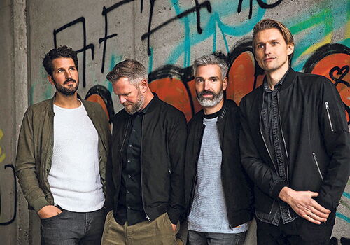 Die Band Jeden Tag Silvester posiert vor Graffiti-Wand.