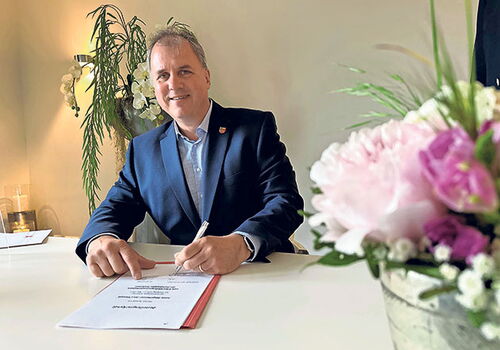Bürgermeister Jan Christoph unterzeichnet ein Dokument.