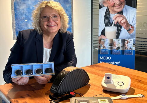 Frau mit Sicherheitsgeräten am Tisch.