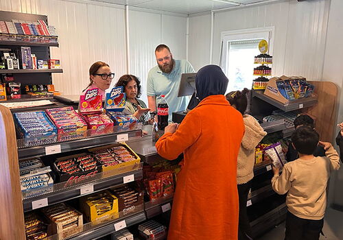 Menschen beim Einkaufen in einem kleinen Geschäft.
