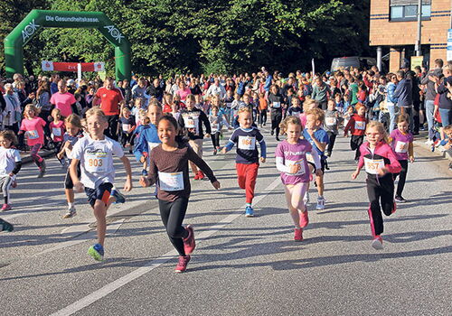 Kinder starten bei einem Laufwettbewerb auf einer Straße.