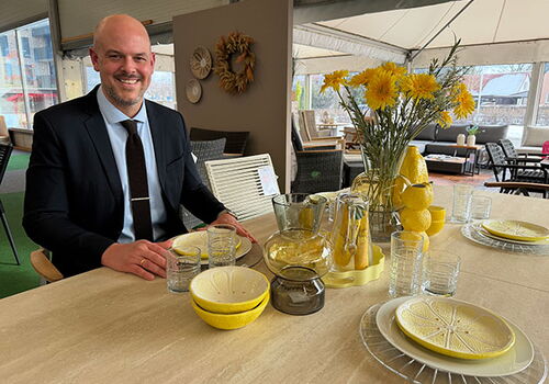 Mann im Anzug an einem Tisch mit Zitronen-Deko.
