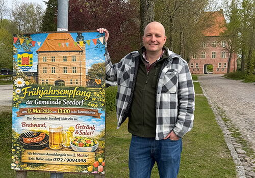 Mann steht neben Plakat für Frühjahrsfest in Seedorf.
