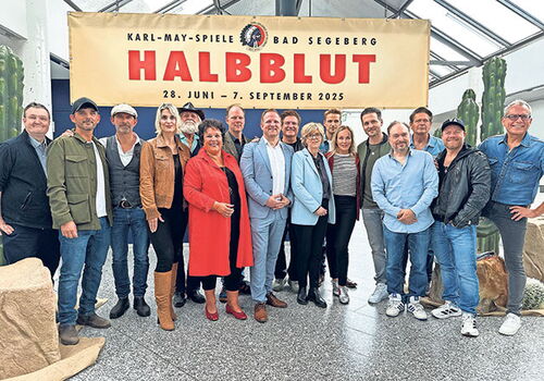 Karl May Ensemble vor Halbbblut Banner posierend.