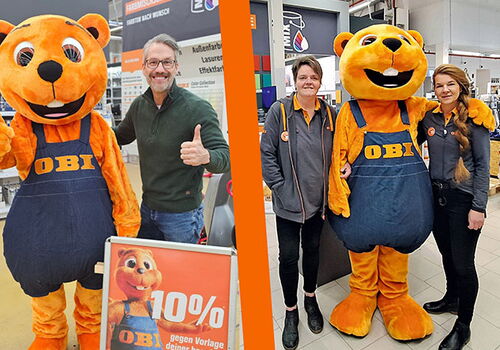 Personen posieren mit OBI-Maskottchen in einem Baumarkt.
