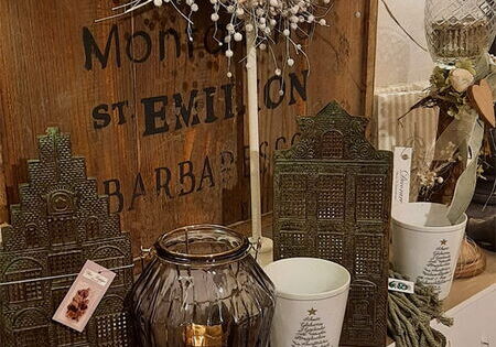 Gemütliches Regal mit Kranz, Kerzen und Deko.